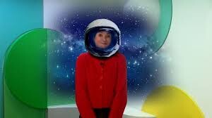 Presentatrice met astronautenhelm op haar hoofd.